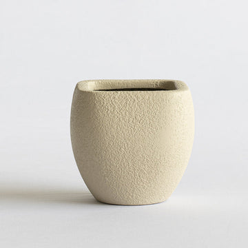 Beige ceramic pot on a light gray background
