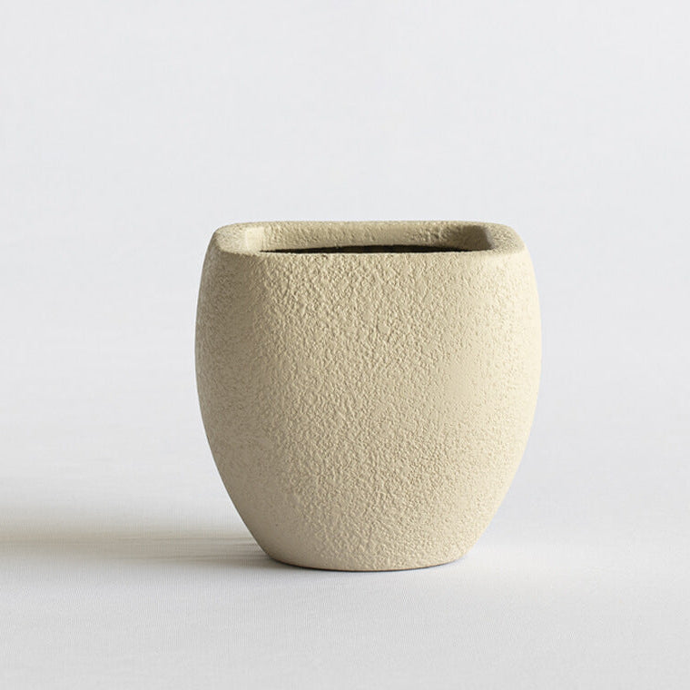 Beige ceramic pot on a light gray background