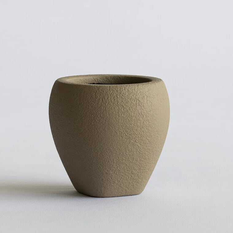 Textured brown ceramic vase on a light gray background