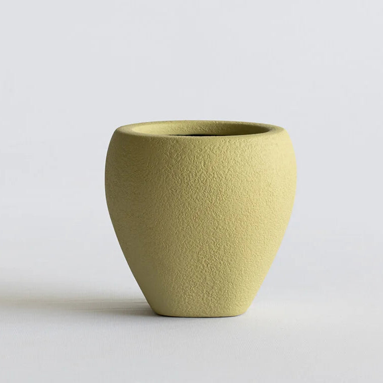 Green ceramic vase on a light gray background