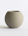 Textured green ceramic pot on a white background