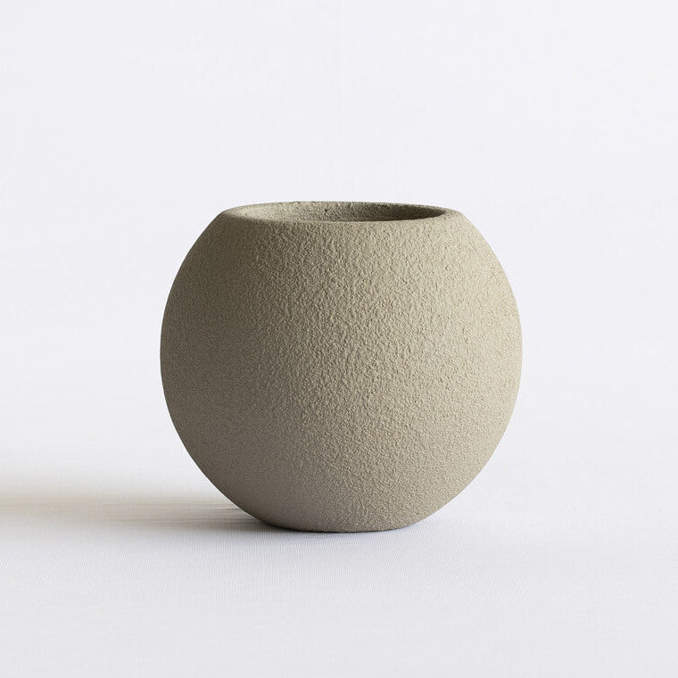 Textured green ceramic pot on a white background