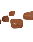 Four exquisite Nomon Isola 5 Walnut (Limited Edition) Wall Clocks, meticulously crafted from solid walnut wood, gracefully hang on a pristine white wall.