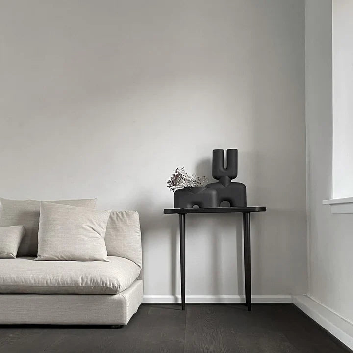 An interior setting of a living room with a 101Cph Cobra Double Medio Coffee 211037 couch and wooden floors, adorned with quirky vases.