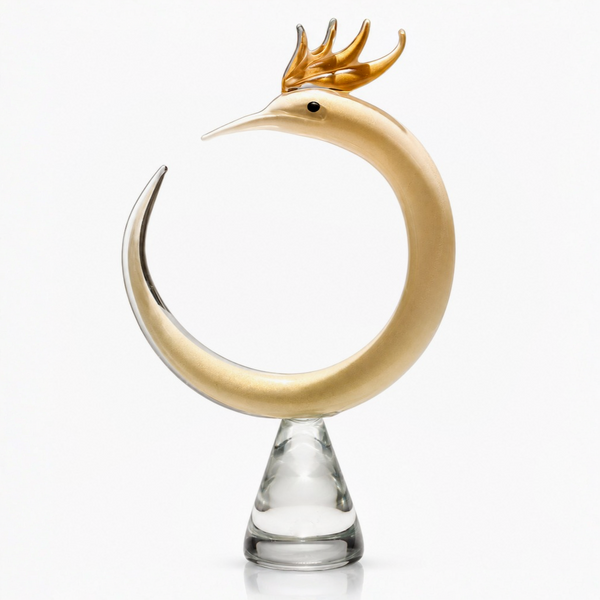 Decorative object resembling a Phoenix with gold antlers on a clear base against a white background