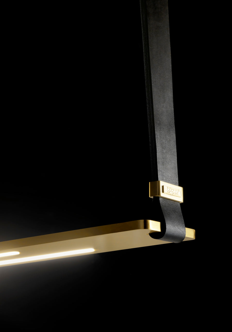 A high-end Esperia Eridania Horizontal Suspension Light, featuring a decorative gold and black pendant, hanging elegantly on a sleek black background.