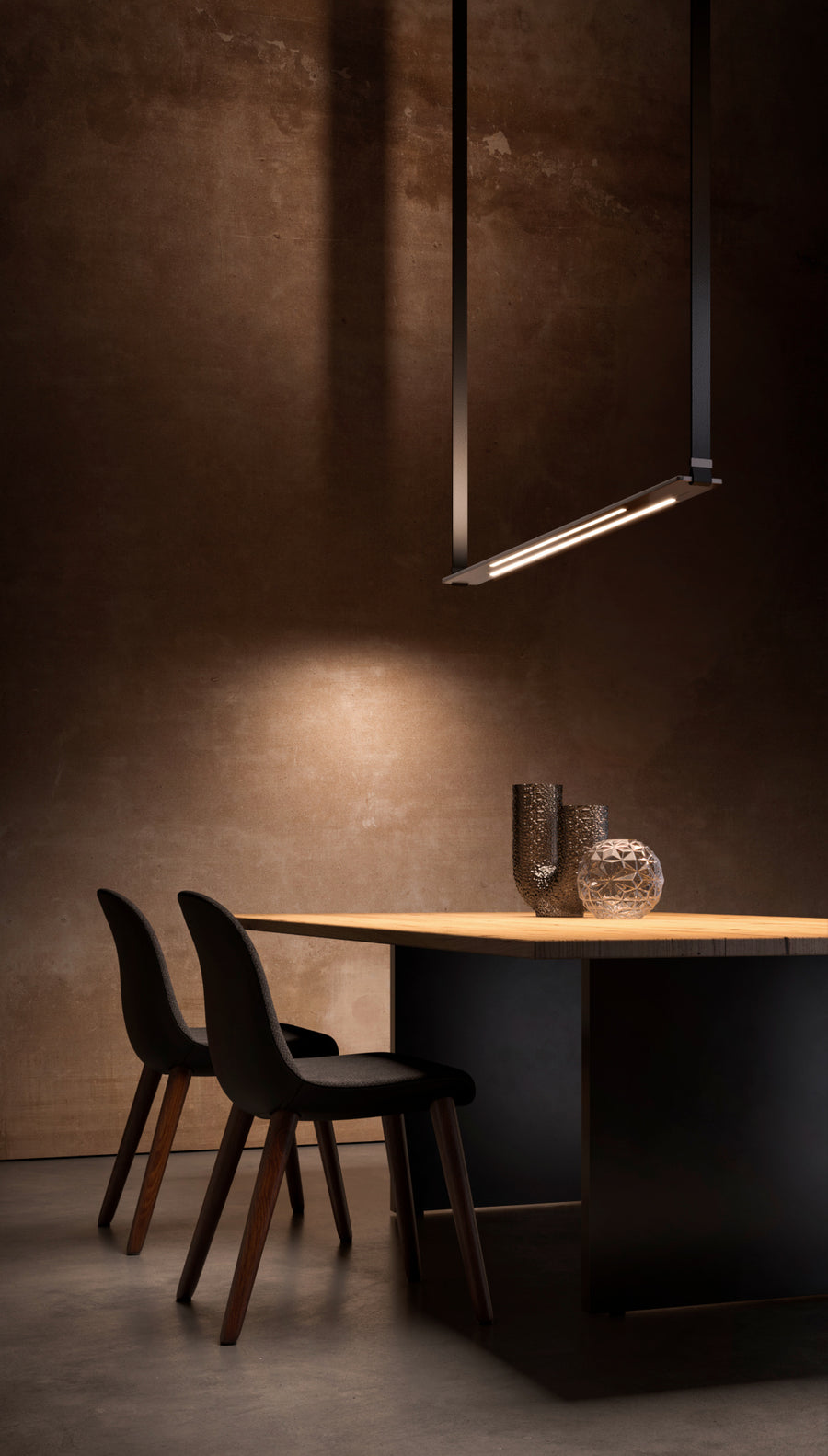 A high-end dining room with a black table and chairs featuring Esperia Eredania Horizontal Suspension Light for decorative lighting.