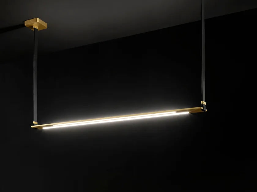 A high-end black room with an Esperia Eridania Horizontal Suspension Light, a gold decorative lighting, hanging from the ceiling.
