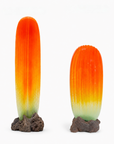 Two ribbed glass sculptures on dark volcanic rock bases, one tall and one short, featuring a vibrant orange and yellow gradient that fades to green at the bottom, set against a plain white background.