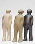 A group of Gardeco Ceramic Sculpture Visitor Small Caqui Cor21 figurines, finished with a caqui finish, standing next to each other on a white surface. These figurines were created by a Belgian sculptor.