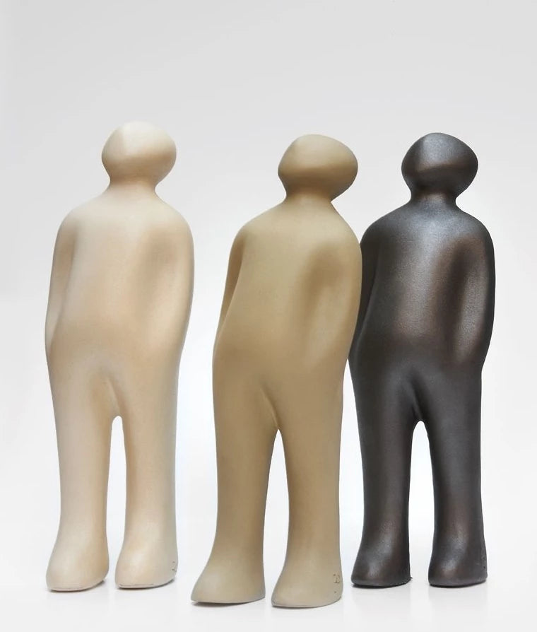 A group of Gardeco Ceramic Sculpture Visitor Small Caqui Cor21 figurines, finished with a caqui finish, standing next to each other on a white surface. These figurines were created by a Belgian sculptor.