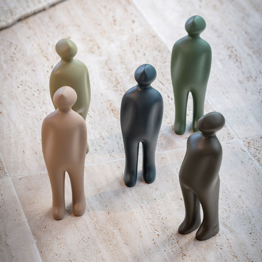 A group of Gardeco Ceramic Sculpture Visitor Small Cinza Cor25 figurines standing on a tile floor, crafted by a Belgian sculptor with a Cinza finish.