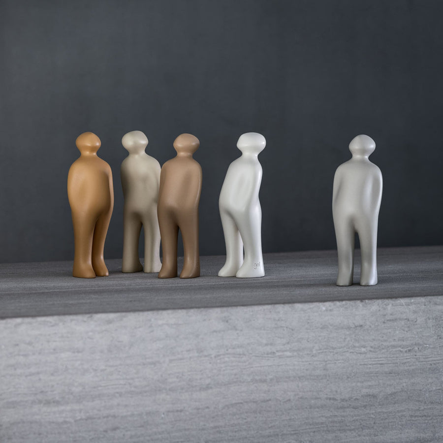 A group of Gardeco Ceramic Sculpture Visitor Small Cinza Cor25 figurines standing on a table, crafted by a Belgian sculptor.