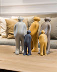 A collection of Gardeco Ceramic Sculpture Visitor Small Cinza Cor25 figurines on a table, showcasing the exquisite craftsmanship of a Belgian sculptor. Each figurine is meticulously crafted with a Cinza finish, creating an elegant display in the.