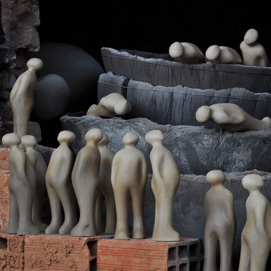 A group of people, including a Belgian sculptor, standing in front of a Gardeco Ceramic Sculpture Visitor Small Cinza Cor25 wall.