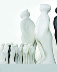 A group of black and white Gardeco Ceramic Sculpture Visitor Small Green Alfafa Black Cor37 figurines standing next to each other with a small figurine, Green Alfafa Black finish.