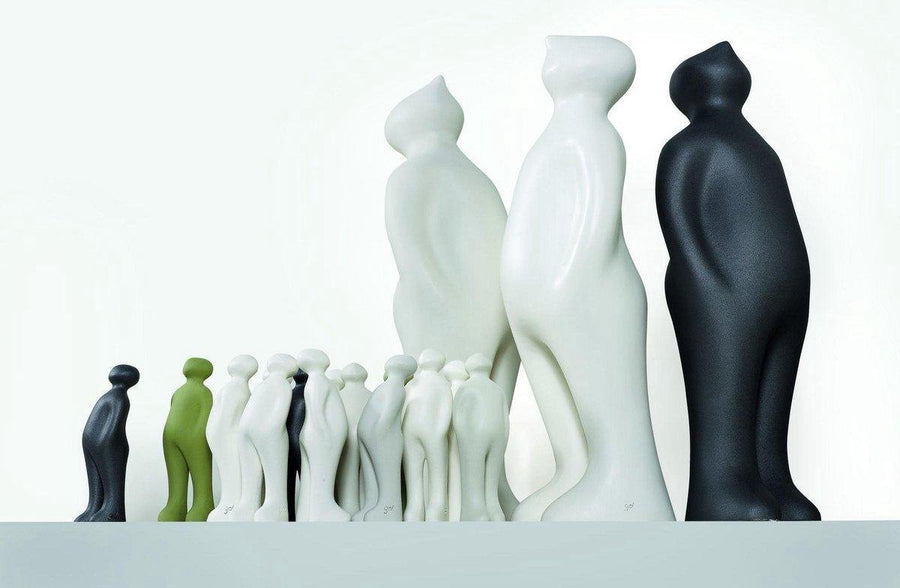 A group of black and white Gardeco Ceramic Sculpture Visitor Small Green Alfafa Black Cor37 figurines standing next to each other with a small figurine, Green Alfafa Black finish.