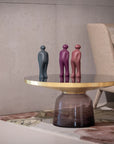 A coffee table in a living room with three Gardeco Ceramic Sculpture Visitor Small Pau Brazil Clear Cor39 figurines on it.