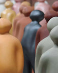 A row of Gardeco Ceramic Sculpture Visitor Small Taupe Cor27 figurines by a Belgian sculptor.