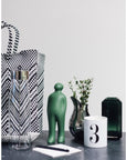 A Gardeco Ceramic Sculpture Visitor Small Verde Cor52 tote bag on a table with a small figurine.