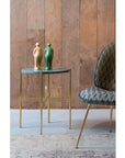 A Gardeco gold and marble side table with a Gardeco Ceramic Sculpture Visitor Small Verde Cor52 on it.