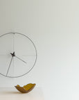 A Gardeco Glass Bowl Mini Mapa Corten luxury clock hanging on an interior wall, featuring an elegant glass bowl design.