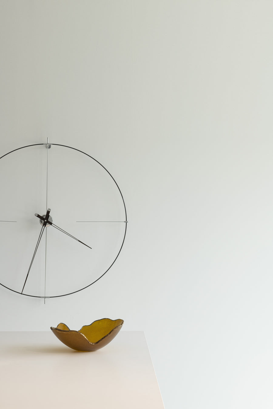 A Gardeco Glass Bowl Mini Mapa Corten luxury clock hanging on an interior wall, featuring an elegant glass bowl design.