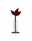 A decorative glass sculpture featuring a sculptural red leaf design on a clear glass body with a black base, set against a plain white background.