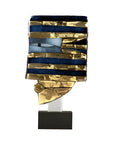 Decorative glass sculpture in gold, blue and black finish on a white background
