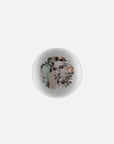 Medium plate with leaves, flowers & human face art on it from Qing Alhambra Rose stack set on a white back ground available at Spacio India for Luxury Home Decor Collection of Tableware Accessories