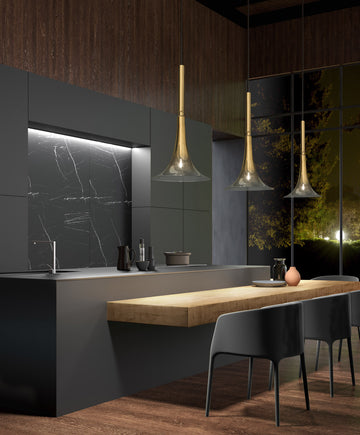 Baffo Collection by Italamp with conical design, titanium finish glass, and matching metal accents, showcasing Italian craftsmanship and elegance. 3 pendant lights over a luxury kitchen counter in gold finish glass