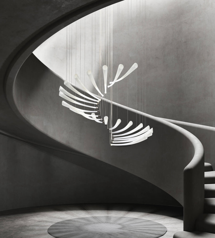 A modern building staircase featuring a stunning Italamp Pulsa Spira chandelier for illumination.