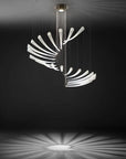 An Italamp Pulsa Spira blown glass chandelier providing illumination in a dark room.