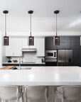 Modern kitchen with white island, black cabinets, and stainless steel appliances and pendant lights from Italamp