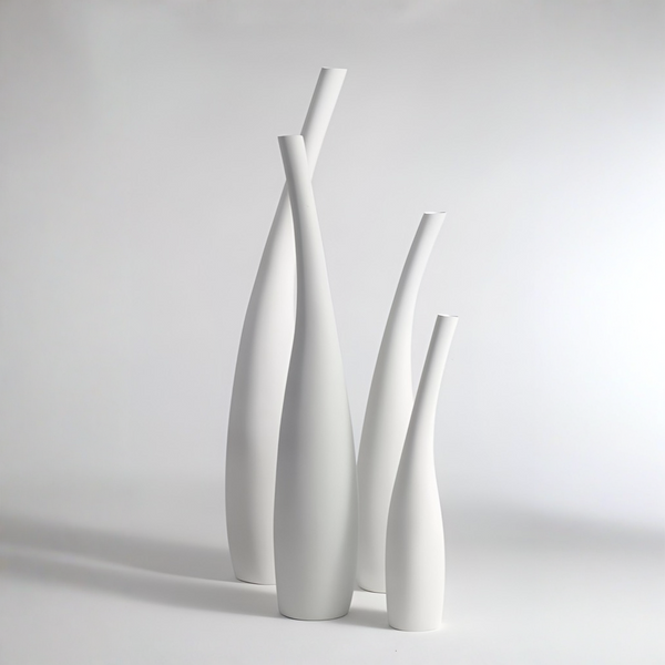 Four minimalist white ceramic vases of varying heights and neck widths, arranged together on a light gray studio background.