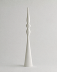 A tall, minimalist white ceramic vase with a flared base and a narrow, bulbous neck, photographed against a seamless light gray background.
