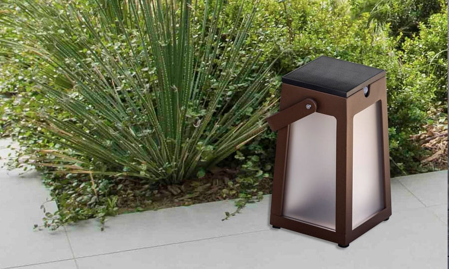 A Les Jardins LJ Solar Lantern Tinka Tink137 300L Muscade provides ambient lighting on a patio.