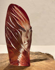 Side look of Maleras Crystal Noviata Red Sculpture on a wooden surface beside a flower vase in modern interior available at Spacio India from Sculpture and Art Objects Collection.