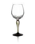 A clear glass wine glass with a textured, dimpled pattern around the lower bowl and a dark, smoky stem and base, shown on a white background with a soft reflection.