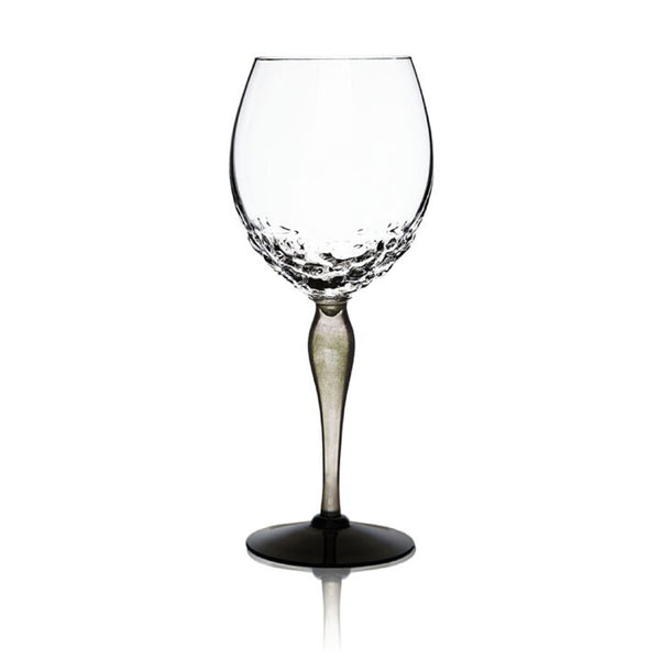 A clear glass wine glass with a textured, dimpled pattern around the base and a slender stem, shown on a plain white background with a soft reflection below.
