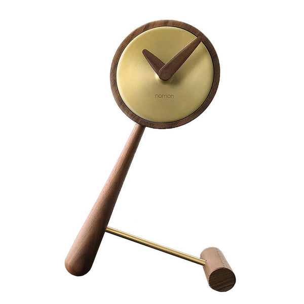 The Clock Nomon Mini Puntero G MPUNG is a high-end designer clock crafted from walnut wood, elegantly displayed on a wooden stand.