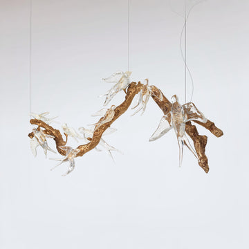 A chandelier with artistic arrangement of branches and white voa birds on a plain background