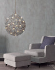 A modern living room with a large Meystyle pendant light featuring ambient lighting, the Germanium LED Wall Paper with Swarovski.