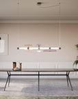 A modern dining room with a large Italamp Axi table and chairs illuminated by a stylish Italamp chandelier.