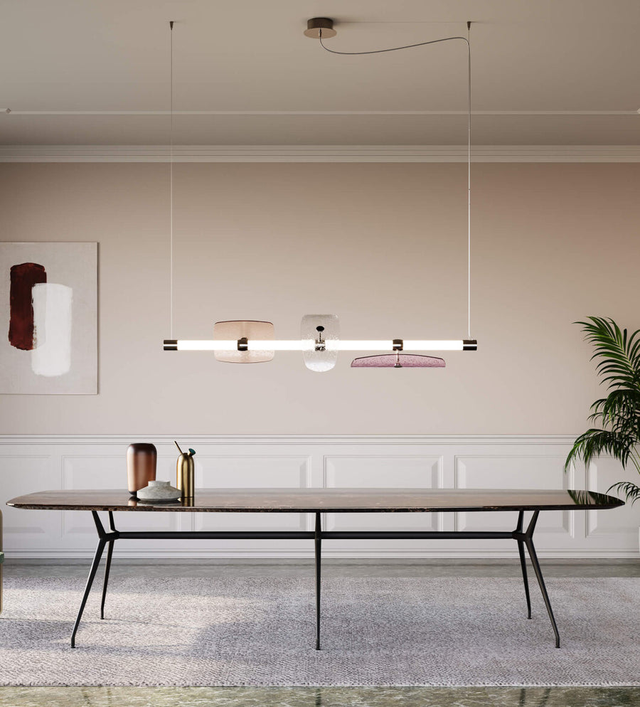 A modern dining room with a large Italamp Axi table and chairs illuminated by a stylish Italamp chandelier.