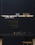 A contemporary designed room with an Italamp Axi table illuminated by an LED light source hanging overhead.