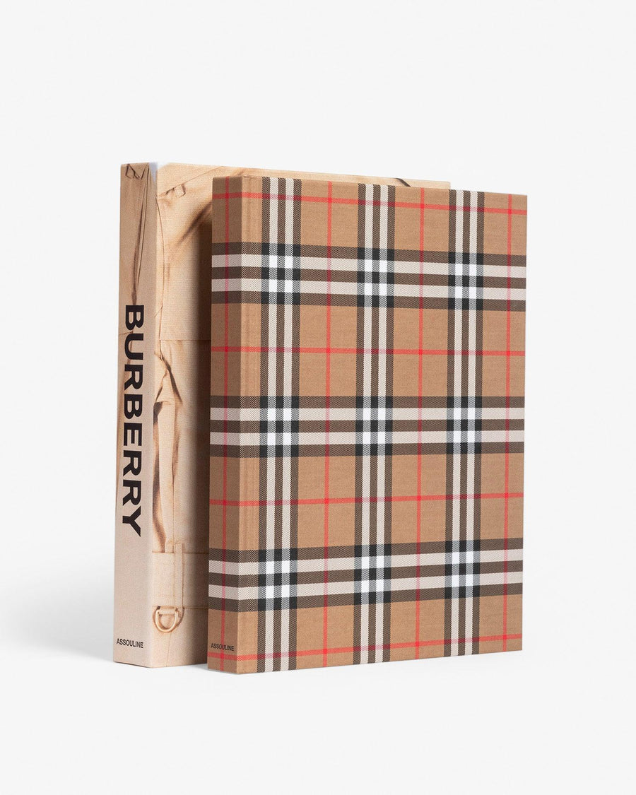 Hardcover and slip case in linen. Burberry coffee table book by Assouline, celebrating 165 years of British style, iconic trench coats, and timeless luxury through stunning illustrations and stories.