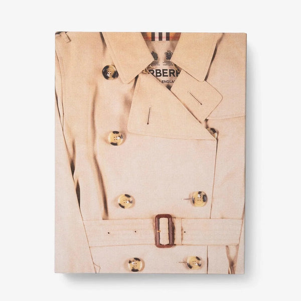 Front slip cover in linen. Burberry coffee table book by Assouline, celebrating 165 years of British style, iconic trench coats, and timeless luxury through stunning illustrations and stories.