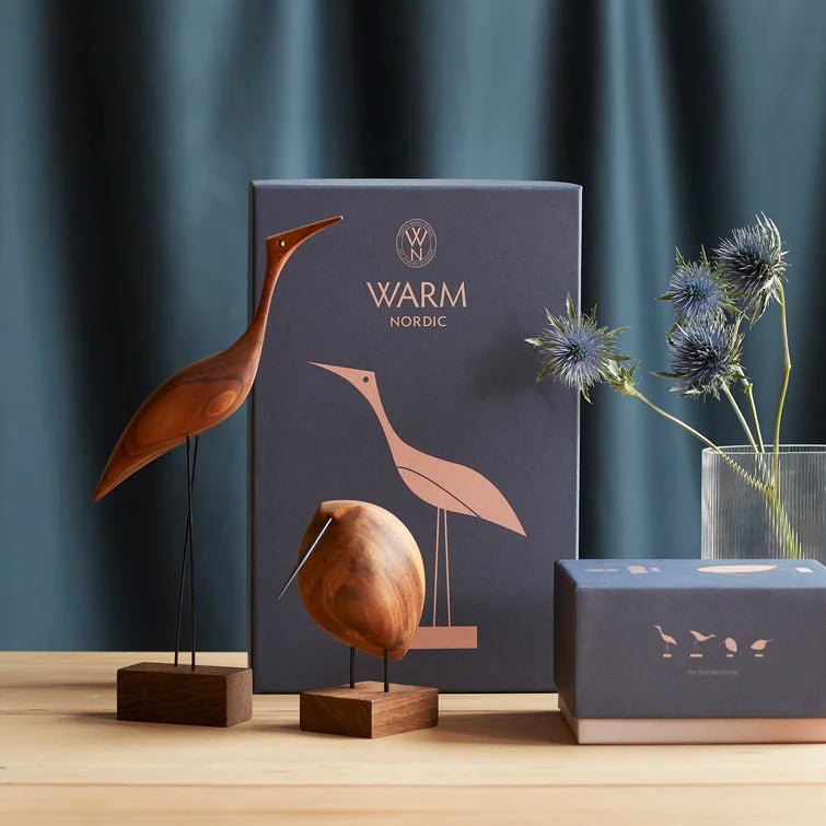 A set of Warm Nordic Beak Bird Tall Heron Oak, including a Heron figurine, arranged on a table.