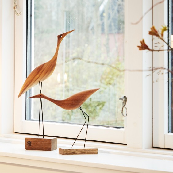 A pair of Warm Nordic Beak Bird Tall Heron Oak birds gracefully perched on a window sill.